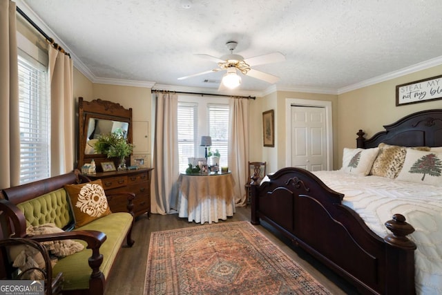 bedroom with ceiling fan, crown molding, and dark wood-type flooring