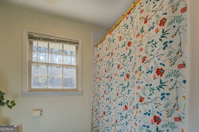 bathroom featuring a wealth of natural light, a textured ceiling, and a shower with curtain