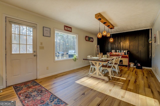 dining room with ornamental molding and light wood-type flooring