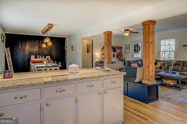 kitchen with hanging light fixtures, white cabinets, ceiling fan, and light hardwood / wood-style flooring