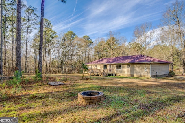 exterior space with a fire pit, a front yard, and a deck