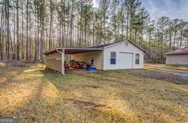 view of outbuilding with a garage, a carport, and a lawn