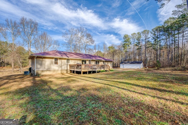 rear view of house featuring a yard and a deck