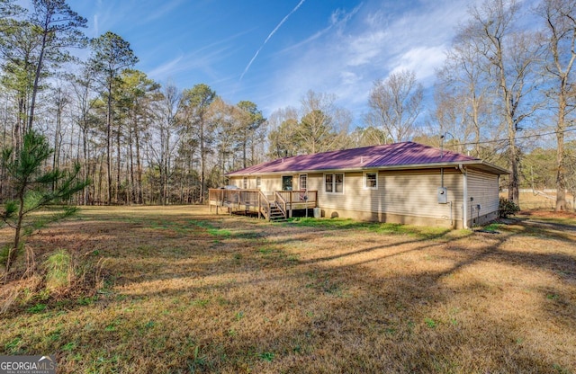 back of house featuring a wooden deck and a yard