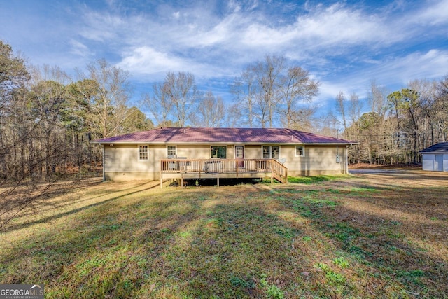 back of property with a deck and a lawn