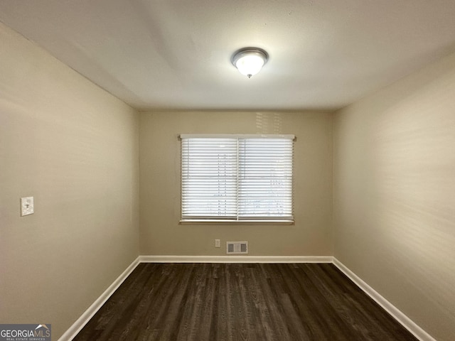 spare room featuring dark wood-type flooring