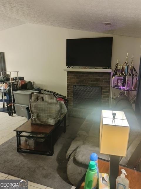 tiled living room with a brick fireplace and a textured ceiling