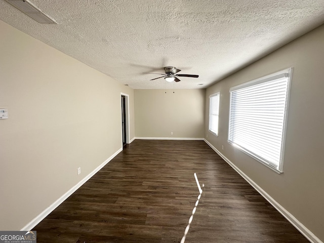 spare room with a textured ceiling, dark hardwood / wood-style floors, and ceiling fan