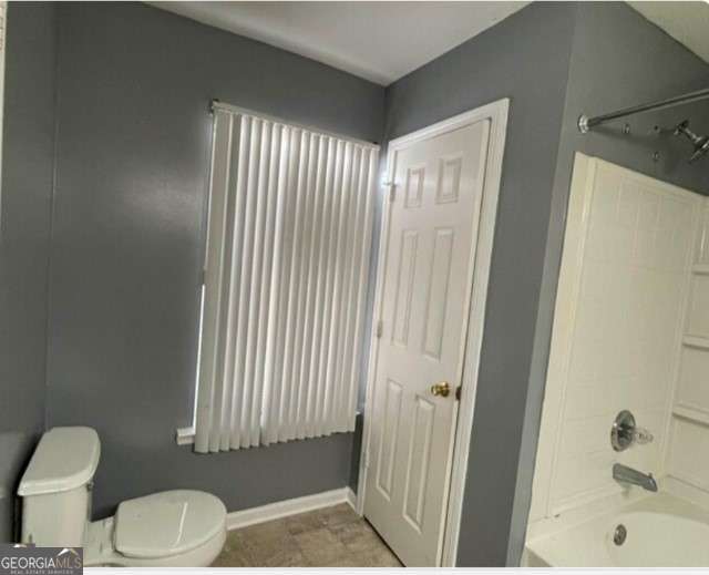 bathroom with toilet and tub / shower combination