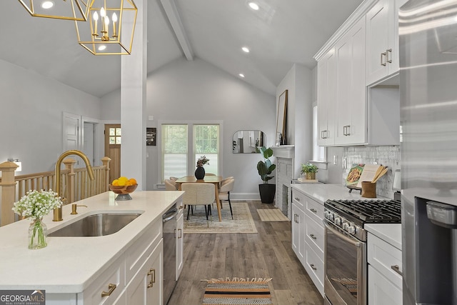 kitchen with stainless steel appliances, dark wood-type flooring, sink, lofted ceiling with beams, and white cabinetry