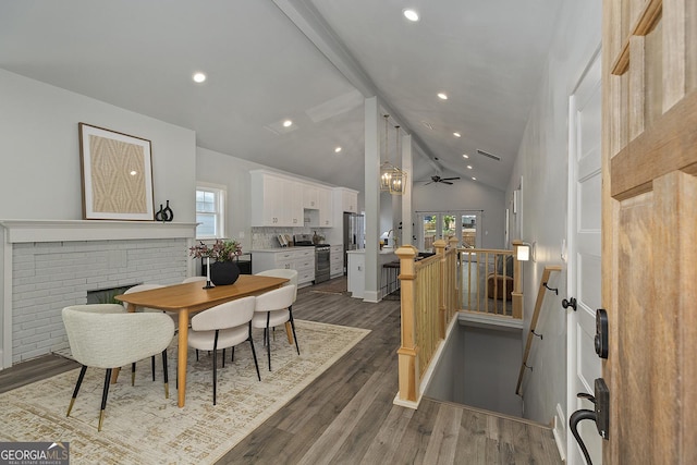 dining room with high vaulted ceiling, dark hardwood / wood-style floors, ceiling fan, and a wealth of natural light