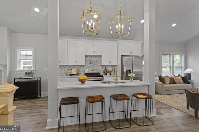 kitchen featuring appliances with stainless steel finishes, light hardwood / wood-style floors, plenty of natural light, and sink