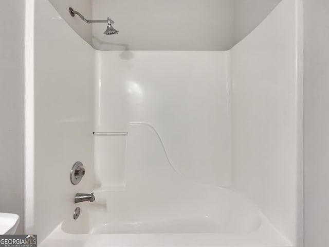 bathroom with shower / washtub combination and toilet