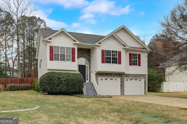 raised ranch featuring a garage and a front lawn