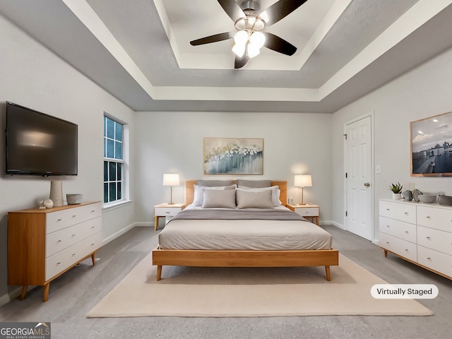 bedroom with a raised ceiling and ceiling fan