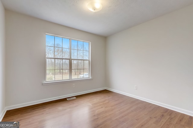 spare room with hardwood / wood-style flooring and a textured ceiling