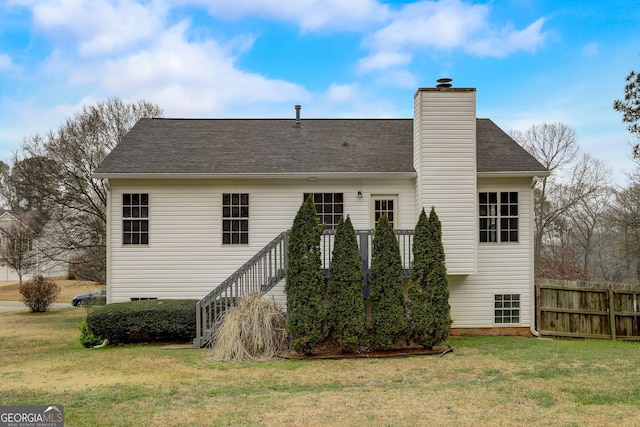 rear view of house featuring a lawn