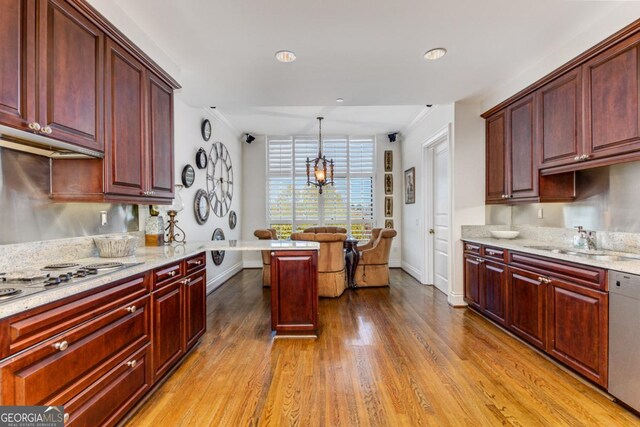 750 Park Ave NE Unit 8E, Atlanta, GA 30326 - kitchen featuring reddish brown cabinets, stainless steel dishwasher, wood finished floors, electric cooktop, and baseboards