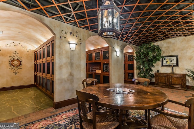 750 Park Ave NE Unit 8E, Atlanta, GA 30326 - wine room featuring baseboards, arched walkways, and lofted ceiling