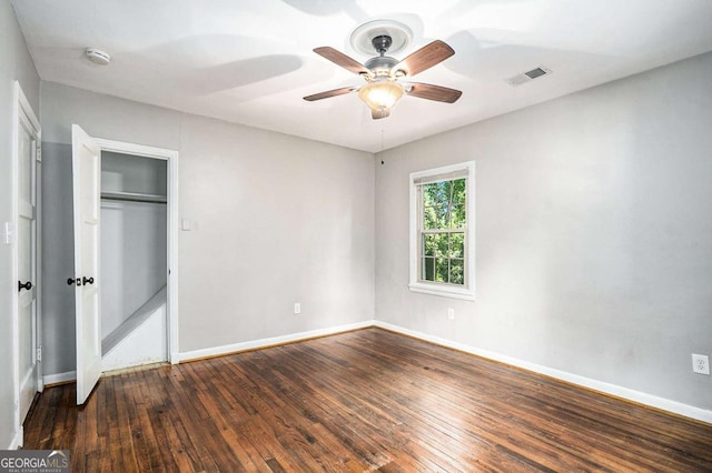 unfurnished bedroom featuring ceiling fan, dark wood-type flooring, and a closet