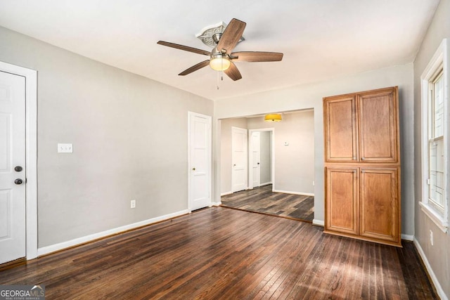 unfurnished bedroom with ceiling fan and dark hardwood / wood-style flooring