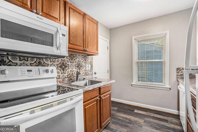 kitchen with backsplash, dark hardwood / wood-style flooring, sink, and white appliances