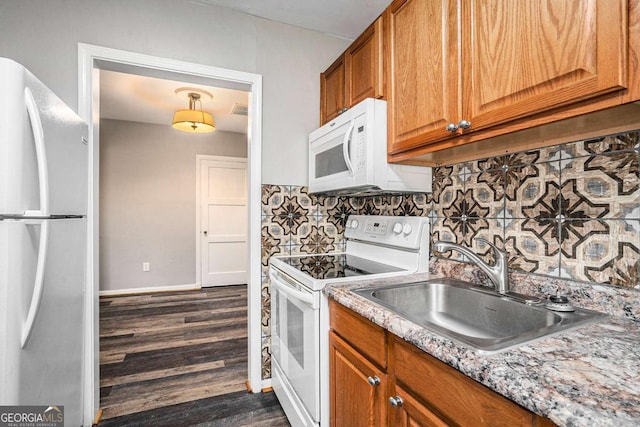 kitchen with white appliances, backsplash, sink, light stone countertops, and dark hardwood / wood-style flooring