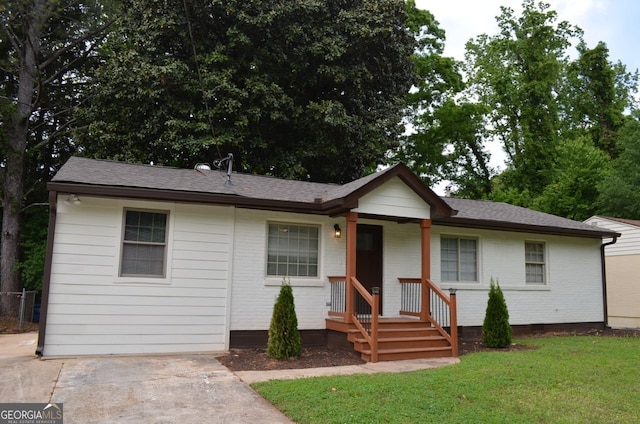 ranch-style house featuring brick siding, a shingled roof, a front lawn, and crawl space