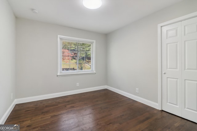 unfurnished bedroom with a closet and dark hardwood / wood-style flooring