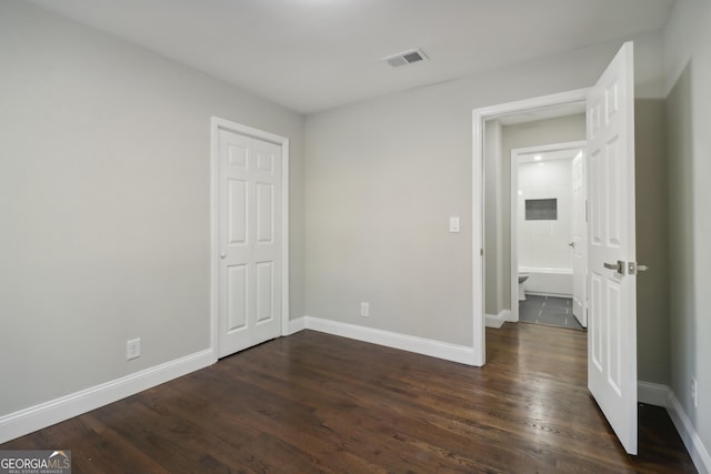 unfurnished bedroom with dark hardwood / wood-style floors