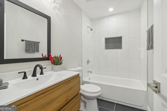 full bathroom featuring tiled shower / bath, tile patterned flooring, vanity, and toilet