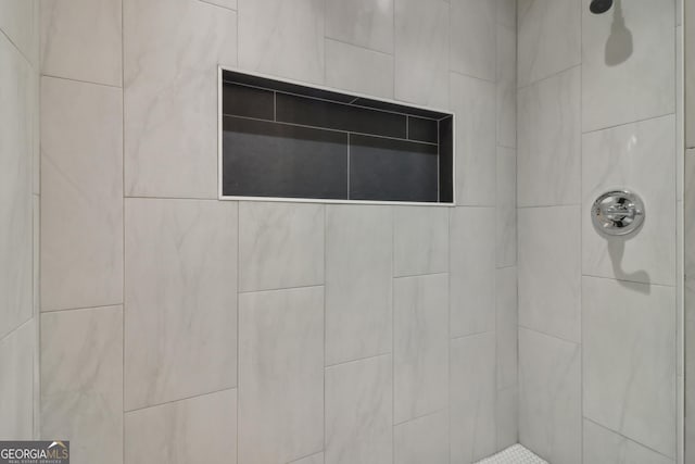 interior details with a tile shower