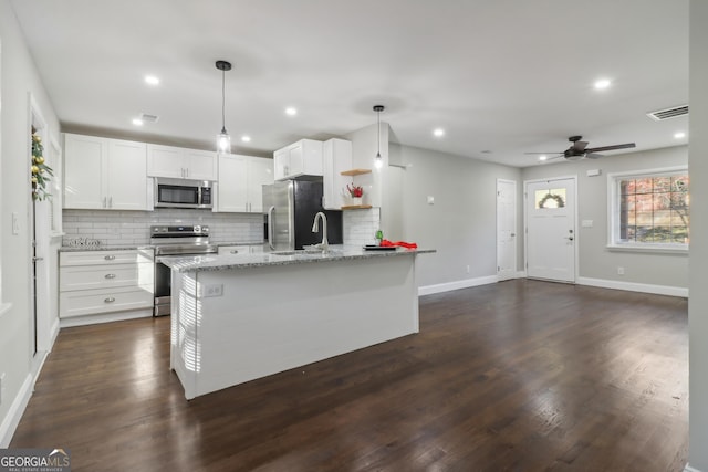 kitchen featuring appliances with stainless steel finishes, decorative light fixtures, white cabinetry, and dark hardwood / wood-style floors