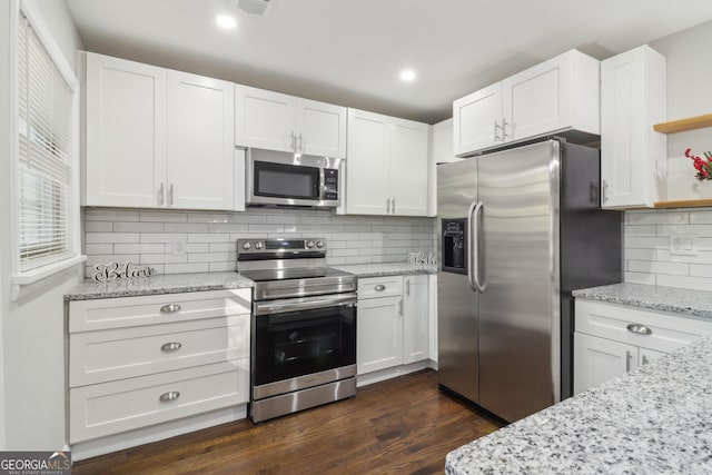 kitchen featuring tasteful backsplash, white cabinets, stainless steel appliances, and dark hardwood / wood-style floors