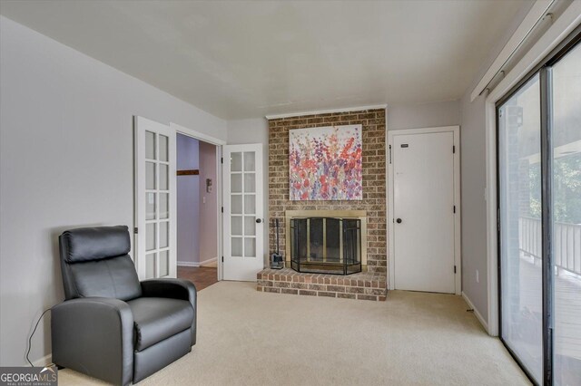 living area with a fireplace, french doors, and carpet floors