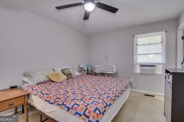 bedroom featuring light colored carpet, ceiling fan, and cooling unit