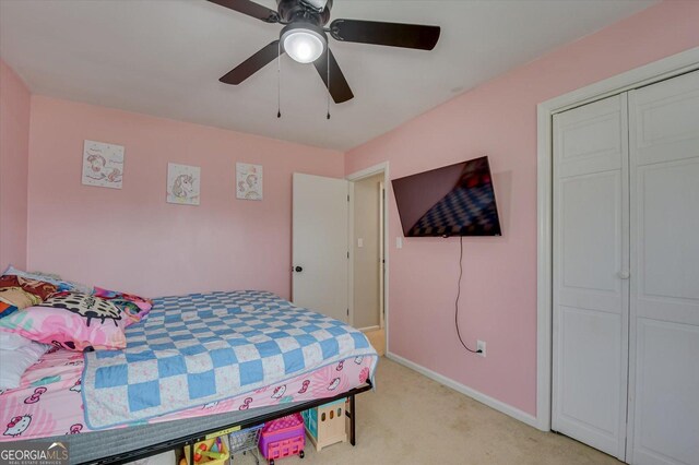 carpeted bedroom featuring ceiling fan and a closet