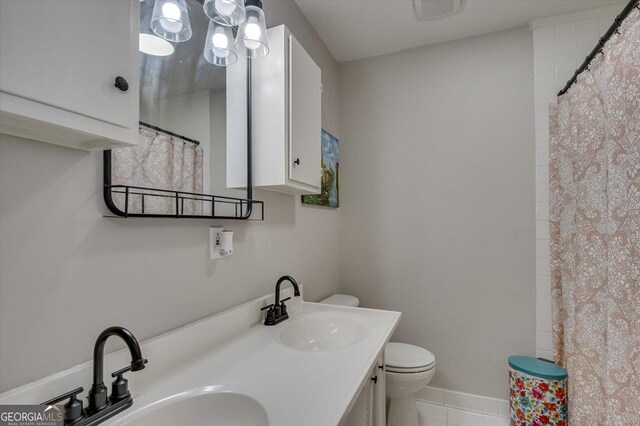 bathroom featuring tile patterned floors, vanity, and toilet