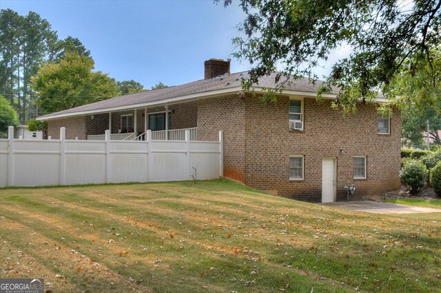 rear view of property featuring a lawn