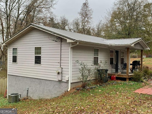 rear view of property with a porch, a yard, and cooling unit