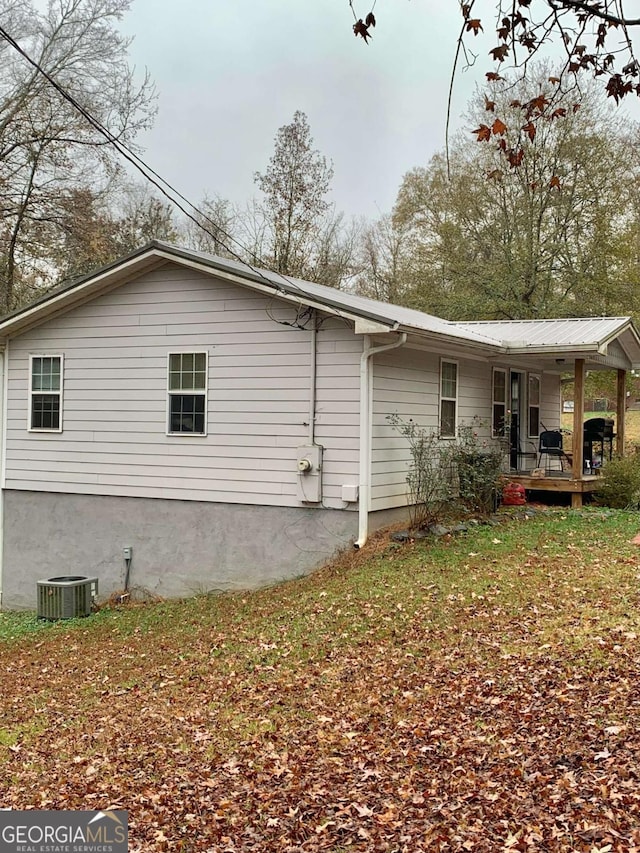 back of house with covered porch, cooling unit, and a lawn