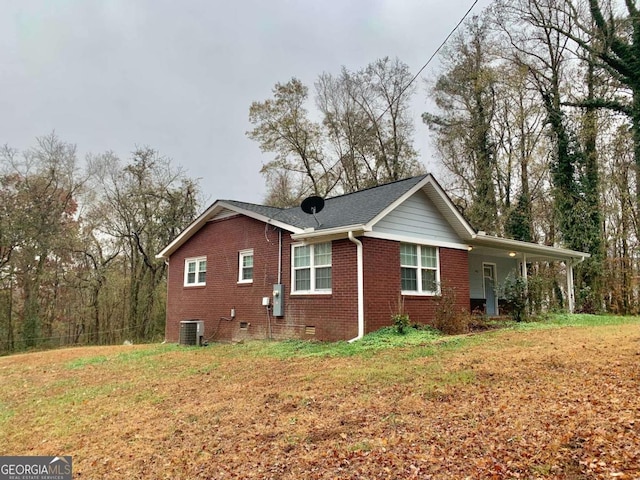 view of side of home with a lawn and cooling unit