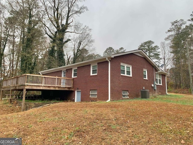 back of property featuring central air condition unit and a wooden deck