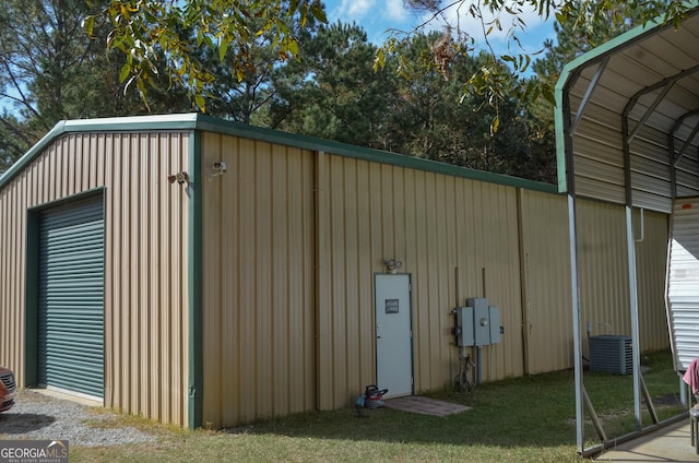 view of outbuilding with a yard, a carport, and central air condition unit