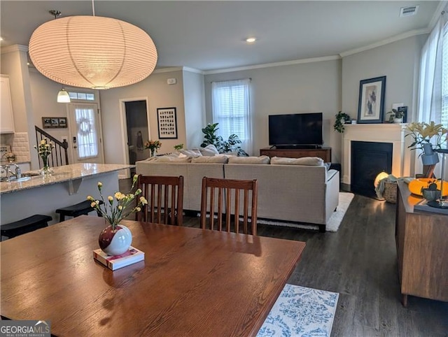 dining space with dark hardwood / wood-style floors and ornamental molding