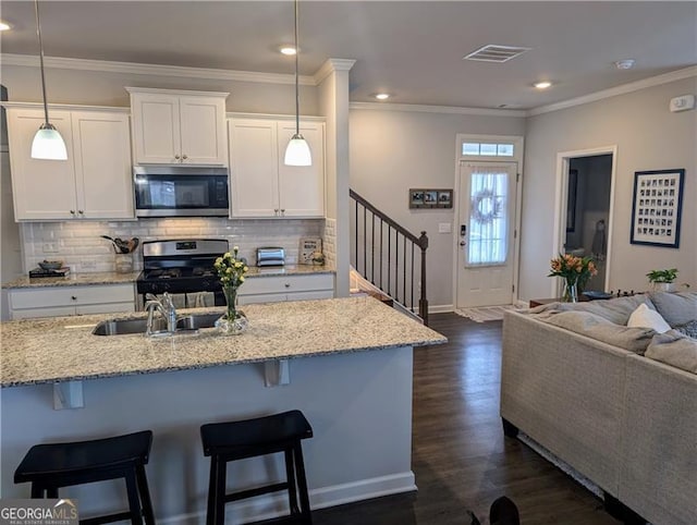 kitchen featuring white cabinets, decorative light fixtures, dark hardwood / wood-style floors, and appliances with stainless steel finishes