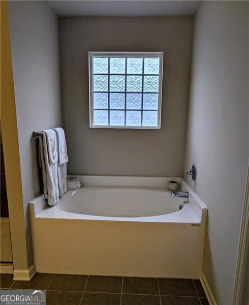 bathroom with a bathtub and tile patterned flooring