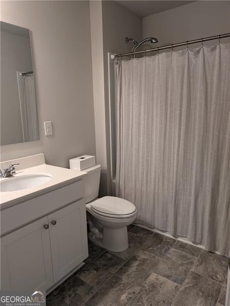 bathroom with vanity, toilet, and walk in shower