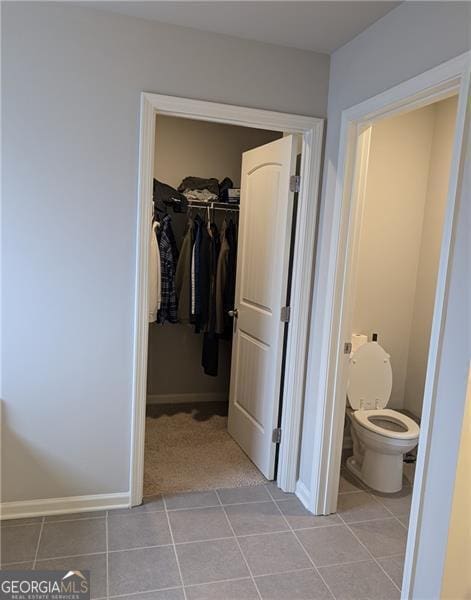 interior space featuring tile patterned flooring and toilet