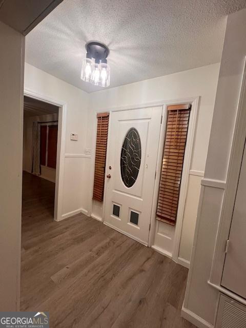 entrance foyer featuring a textured ceiling and dark wood-type flooring